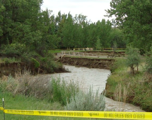 Flood aftermath with collapsed bridge, and much wider river